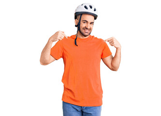 Young handsome man wearing bike helmet looking confident with smile on face, pointing oneself with fingers proud and happy.