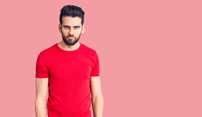 Young handsome man with beard wearing casual t-shirt skeptic and nervous, frowning upset because of problem. negative person.