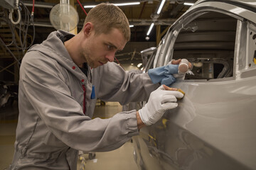 Employee car body painting shop eliminates a small metal defect