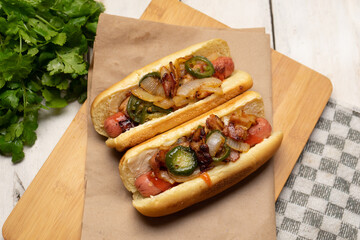 Hot dog with jalapeno pepper, bacon and caramelized onion on white background