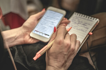 Woman making entry into notepad . Writer makes a novel.