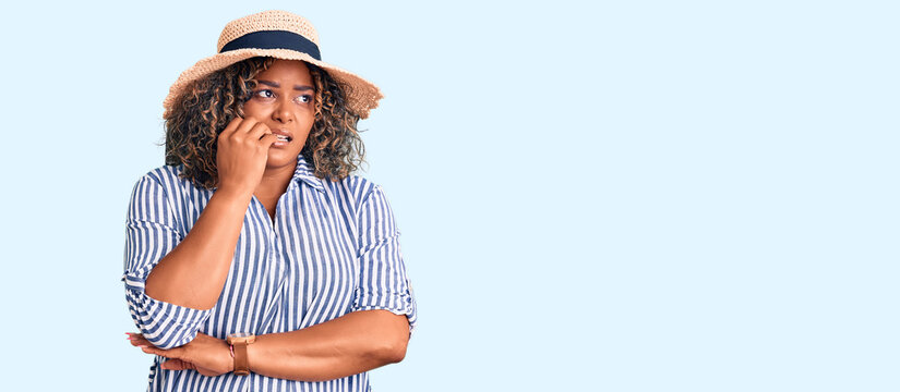 Young african american plus size woman wearing summer hat looking stressed and nervous with hands on mouth biting nails. anxiety problem.