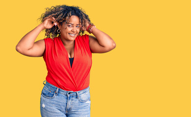 Young african american plus size woman wearing casual style with sleeveless shirt smiling pulling...