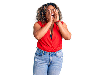 Young african american plus size woman wearing casual style with sleeveless shirt shouting angry out loud with hands over mouth