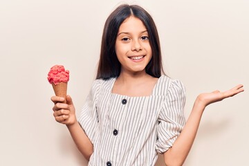 Beautiful child girl holding ice cream celebrating achievement with happy smile and winner...