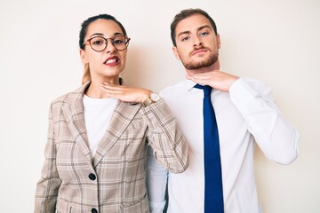 Beautiful couple wearing business clothes cutting throat with hand as knife, threaten aggression with furious violence