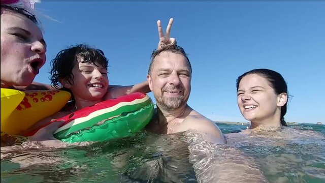 happy smiling parents and kids float on rubber ring at sea, family vacation, concept.