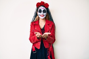Woman wearing day of the dead costume over white smiling with hands palms together receiving or giving gesture. hold and protection