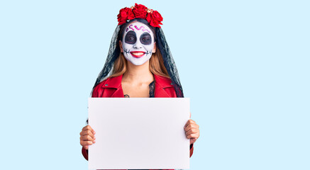 Woman wearing day of the dead costume holding blank empty banner looking positive and happy standing and smiling with a confident smile showing teeth