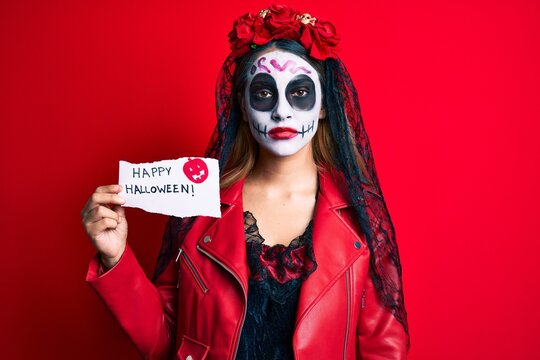 Woman Wearing Day Of The Dead Costume Holding Happy Halloween Paper Thinking Attitude And Sober Expression Looking Self Confident