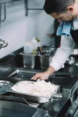 professional chef frying rice noodles in oil in the restaurant kitchen
