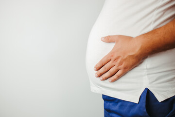 Overweight man holding big belly, copy space