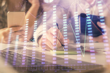 Double exposure of man and woman working together and financial graph hologram. Business concept....