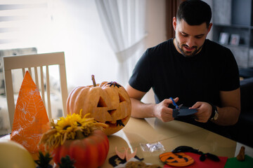 Father and children make decorations for Halloween at home.