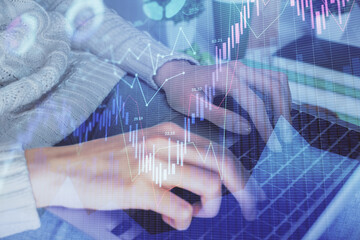 Double exposure of woman hands typing on computer and forex chart hologram drawing. Stock market invest concept.