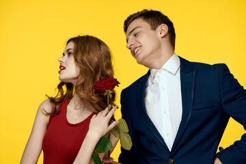 Young charming couple rose relationship romance gift as a lifestyle yellow isolated background