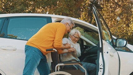 Elderly couple. Man taking care of his elderly disabled wife. High quality photo - obrazy, fototapety, plakaty