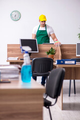 Young male contractor cleaning the office