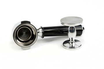 Black and silver coffee filter holder on its side by a metal tamper