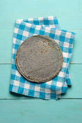 Mexican blue corn tortilla on turquoise background