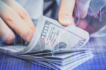 Multi exposure of forex graph drawing hologram and USA dollars bills and man hands. Technical...