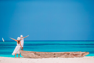 Beautiful mother and daughter at Caribbean beach enjoying summer vacation.