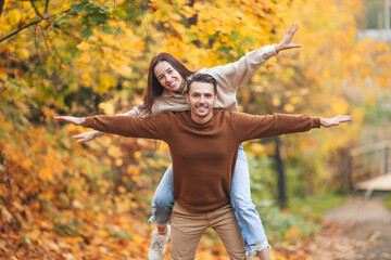 Happy family walking in autumn park on sunny fall day