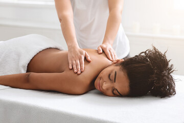 Female therapist rubbing sleeping african american lady back