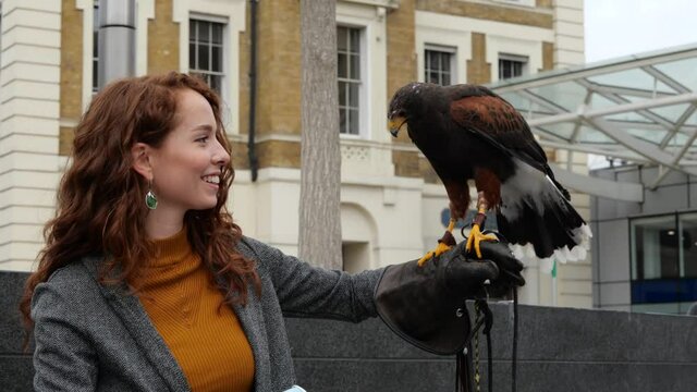 Red haired woman interacting with hawk 