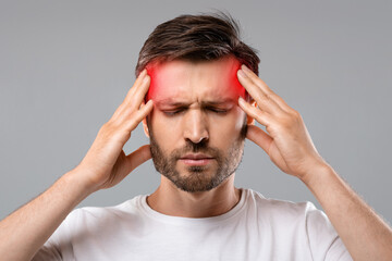 Man suffering from headache, touching his temples