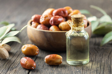 Glass bottle of silverberry oil and fresh raw silverberry fruits with bunch of silverberry tree, oleaster or russian olive ( Elaeagnus )