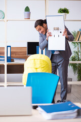 Young male employee looking after newborn at workplace