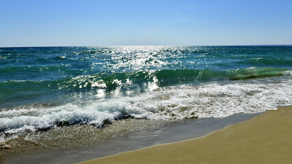 Fototapeta na wymiar Foamy sea surf. Beautiful azure waves. Sand beach.