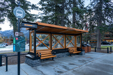 Street view of Town of Banff. Bus stop in Banff Avenue in autumn and winter snowy season. Banff, Alberta, Canada.