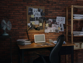 Workplace with laptop and detective board in office