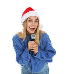 Happy woman in Santa Claus hat singing with microphone on white background. Christmas music