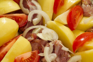 pork meat, potatoes, tomatoes and onions, ready to bake