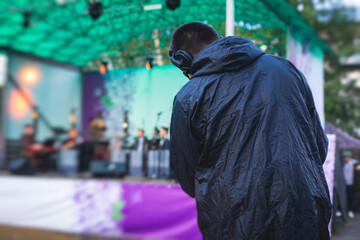 Obraz premium View of a camera man operator working during tv reportage, online broadcasting of concert, professional videographer with camera filming live event