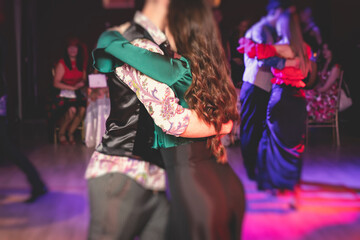 Couples dancing traditional latin argentinian dance milonga in the ballroom, tango salsa bachata...