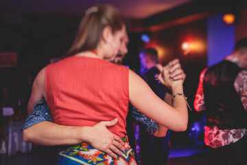 Couples dancing traditional latin argentinian dance milonga in the ballroom, tango salsa bachata...