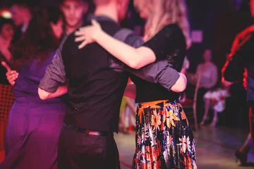 Fotobehang Couples dancing traditional latin argentinian dance milonga in the ballroom, tango salsa bachata lesson in the red lights, dance festival © tsuguliev