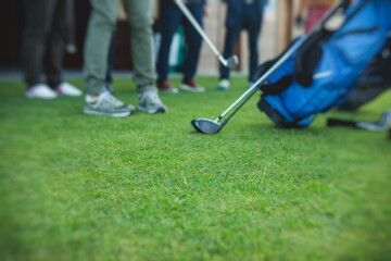 Group of golfers practicing and training golf swing on driving range practice, men playing on golf course, golf ball at golfing complex club resort