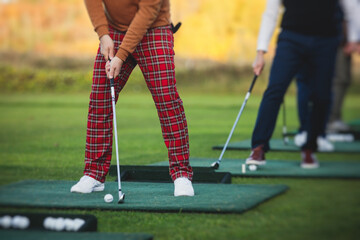 Group of golfers practicing and training golf swing on driving range practice, men playing on golf...