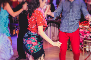 Obraz premium Couples and women wearing red skirts and dress dancing traditional gypsy dance in the ballroom hall