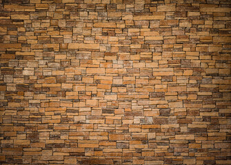 background and texture of yellow decorative stone wall surface.