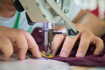 Employee's hands working with his sewing machine in clothing factory