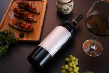 Bottle of wine lying down in black background with some food as decoration