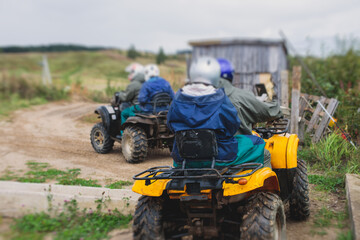 Group of riders riding atv vehicle on off road track, process of driving ATV vehicle, all terrain quad bike vehicle, during offroad competition, crossing a puddle of mud