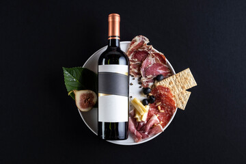Bottle of wine lying down in black background with some food as decoration