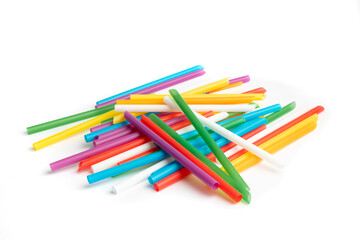 A pile of colorful single use plastic straws isolated on white